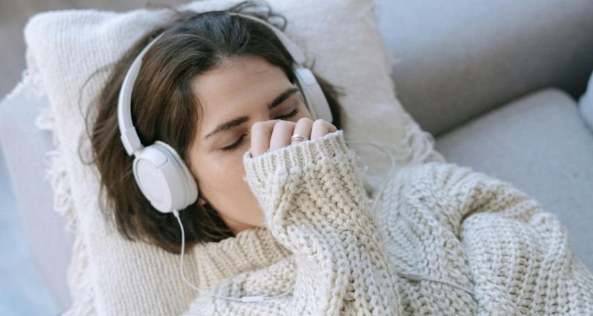 A Woman wearing Headphone Lying on the Couch