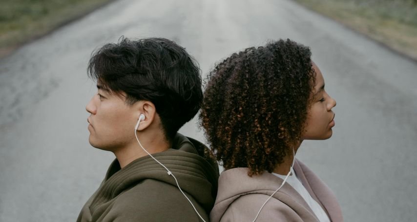 A Man and Woman Listening to Music Using Headphones
