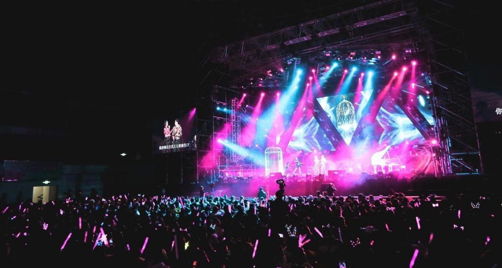 artists giving concert in hall with audience